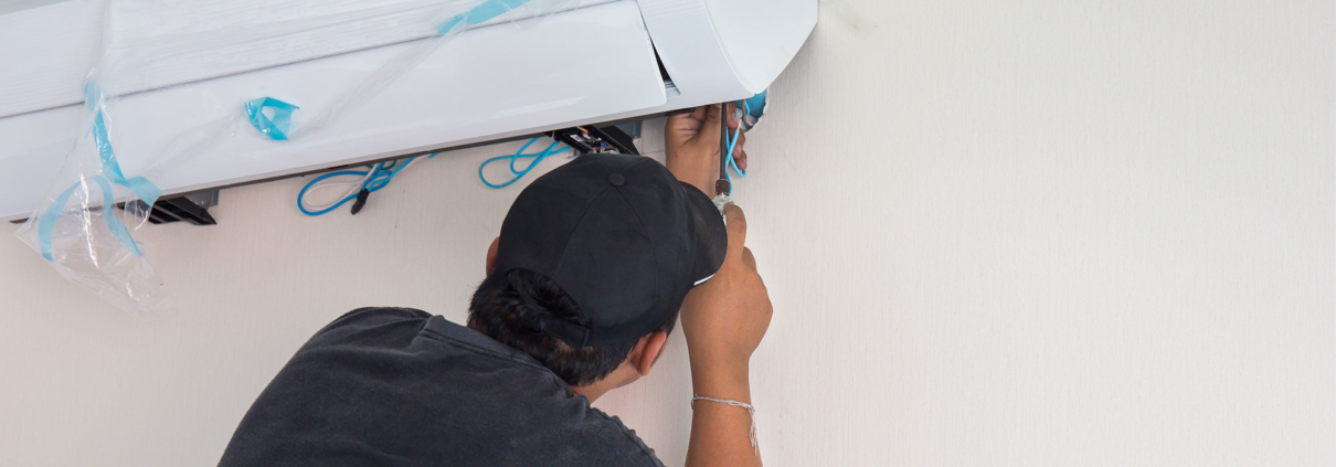 JohnΓÇÖs Service and Sales man installing air unit in home