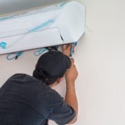 JohnΓÇÖs Service and Sales man installing air unit in home