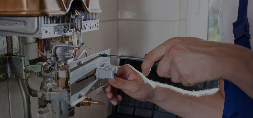 on-demand-water-heaters_handyman-adjusting-water-heater